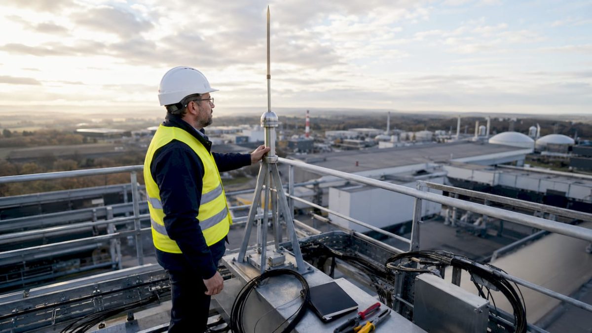Un ingénieur procède à la vérification d’un paratonnerre sur un site industriel.