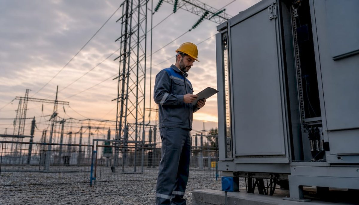 Engineer inspecting high voltage substation equipment