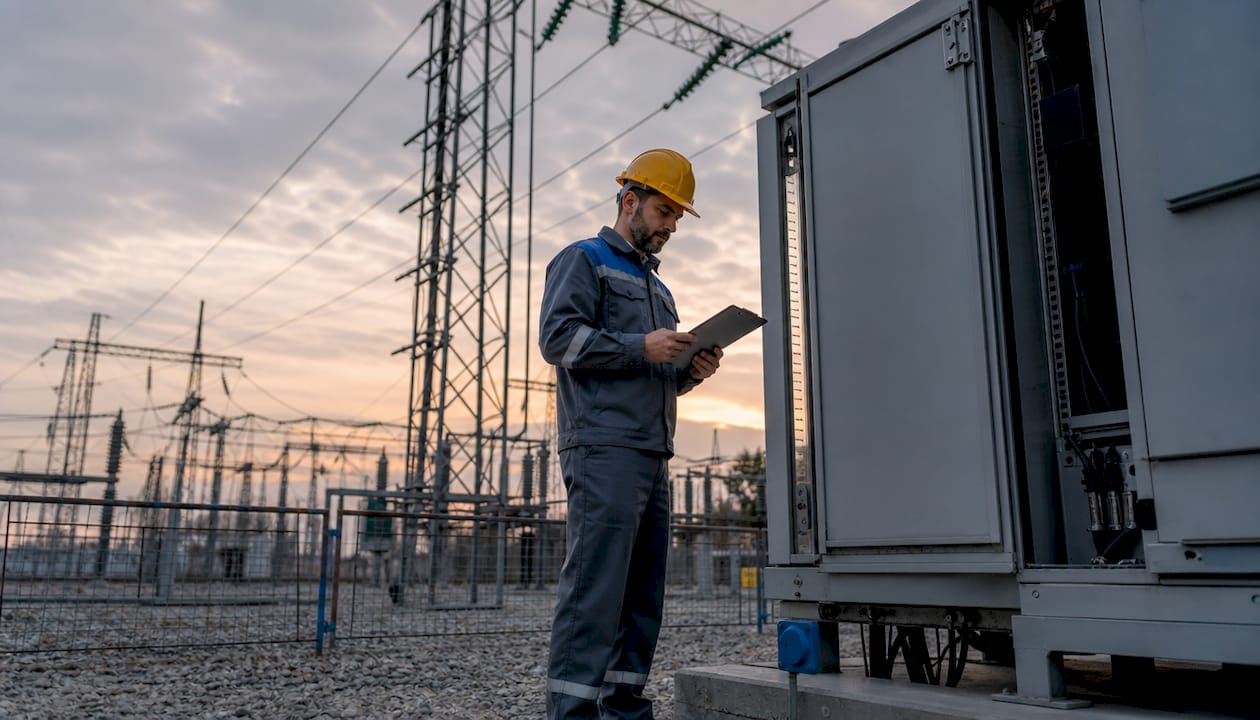 Engineer inspecting high voltage substation equipment