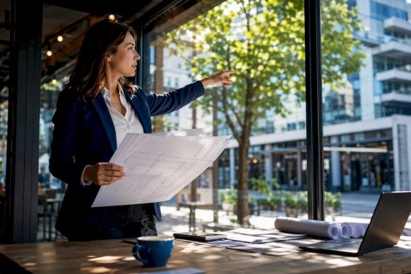 Architect reviewing glass facade blueprint
