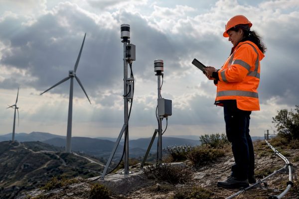Une technicienne sur le terrain effectue le contrôle des capteurs de détection de la foudre en extérieur.