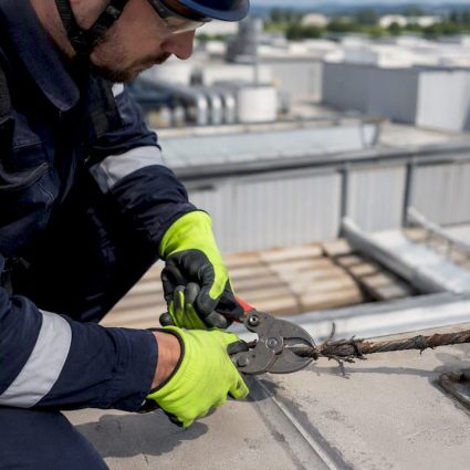 Un technicien en train de sectionner un câble de paratonnerre