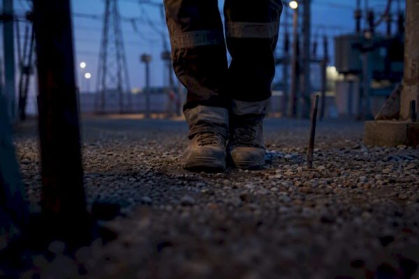 Worker shuffling feet together on industrial grounding soil