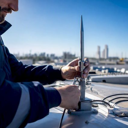 Technician installing lightning rod on rooftop