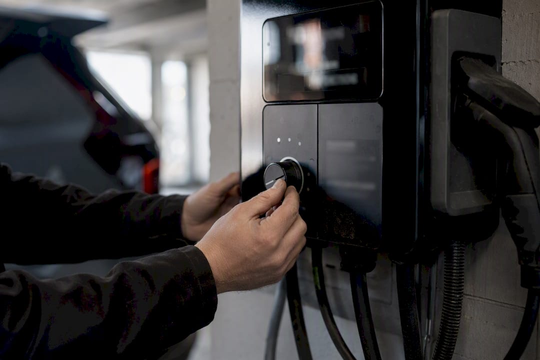 Technicien réglant le panneau d'une station de recharge électrique