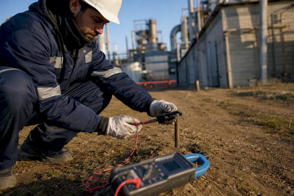 Technician testing grounding rod on site