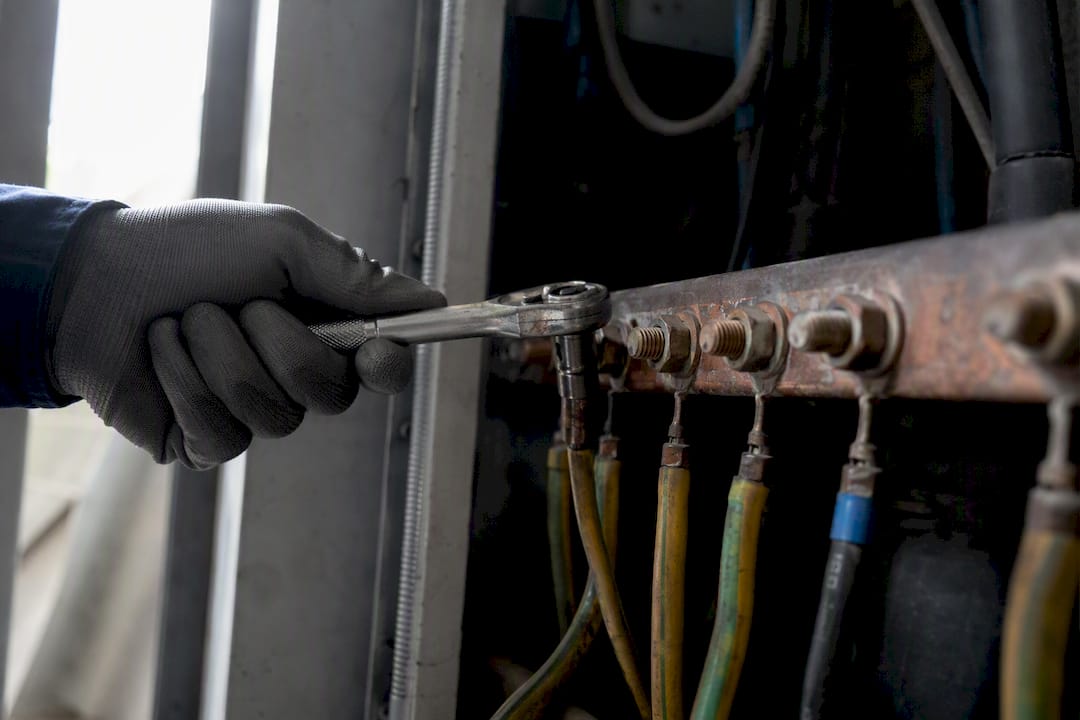 Technician tightening bonding terminal with torque wrench