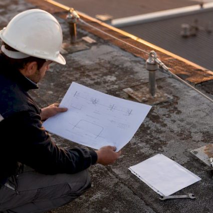 Technicien analysant les plans et la ligne de vie sur le toit