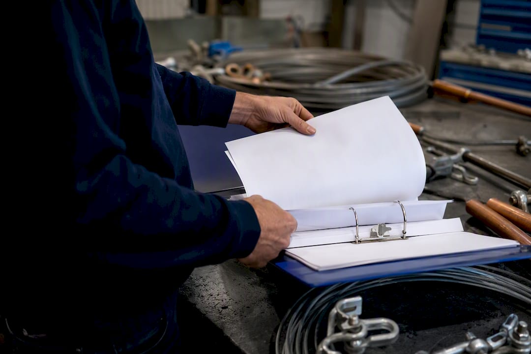 Hands handling lightning protection documentation binder
