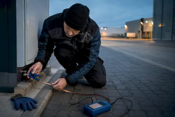 Technician checking industrial charging grounding connection