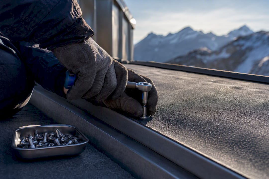 Technician securing roof fixing above waterproof membrane
