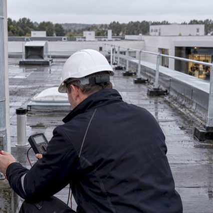 Auditeur vérifiant une installation de protection contre la foudre dans un ERP