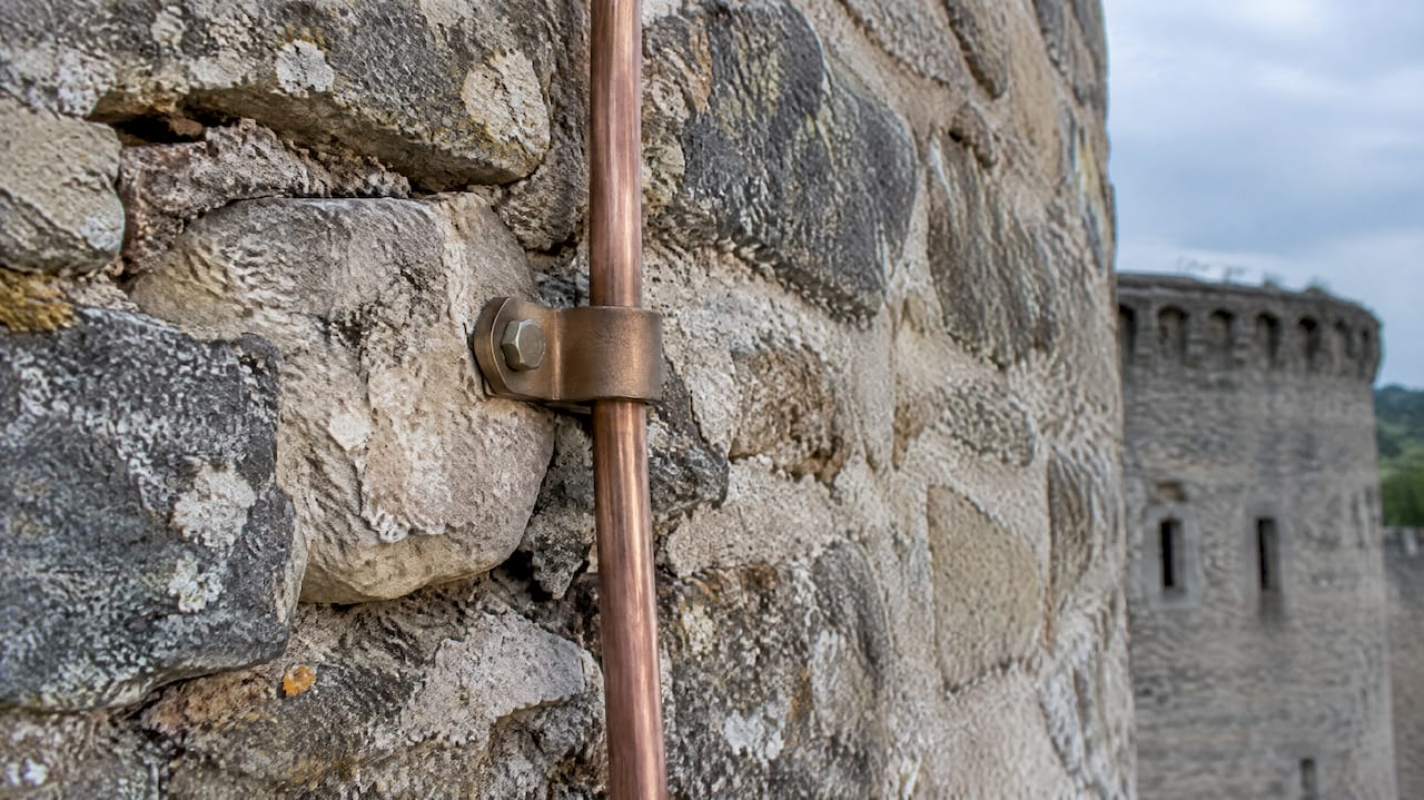Clamped down conductor on rubble stone masonry
