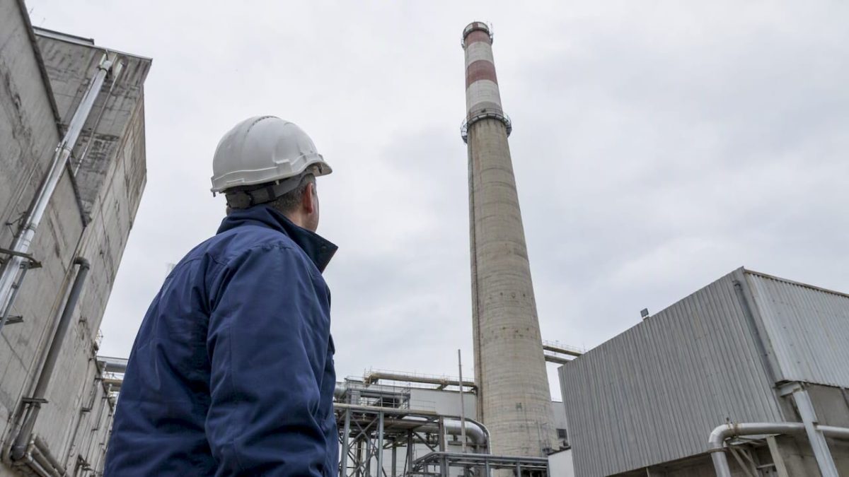 Engineer assessing a tall industrial chimney