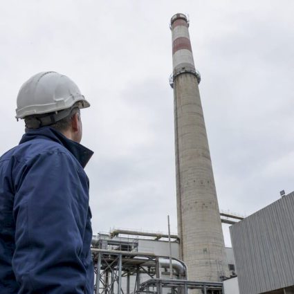 Engineer assessing a tall industrial chimney