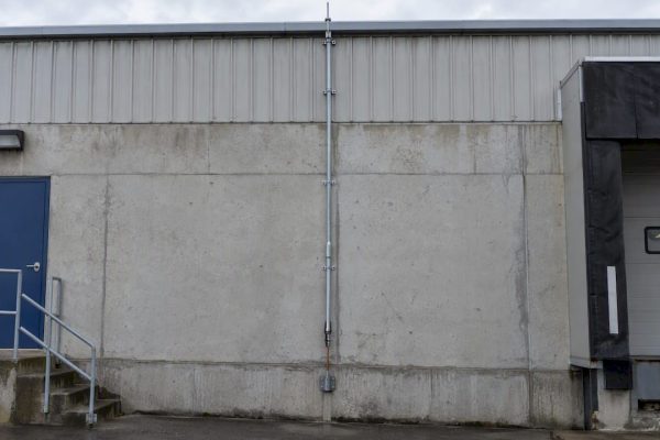 Down conductor routed along an industrial facade