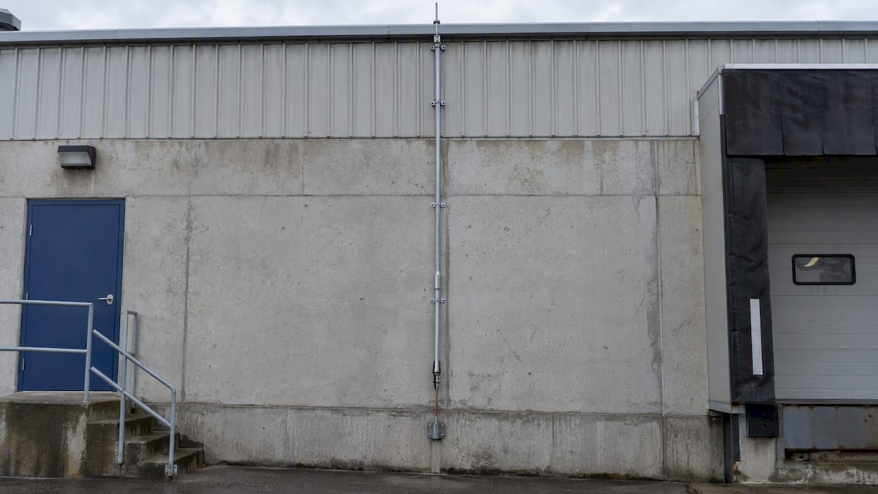 Down conductor routed along an industrial facade