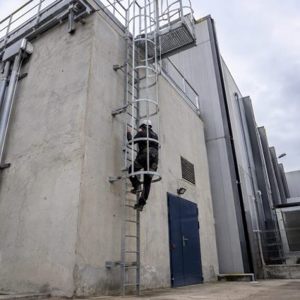 Échelle fixe avec crinoline sur bâtiment industriel