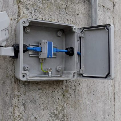 Data-line surge protector inside an outdoor enclosure